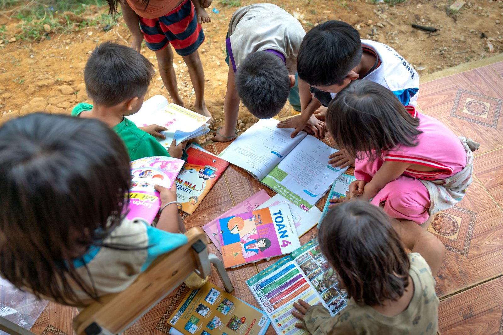 Children reading books outdoors